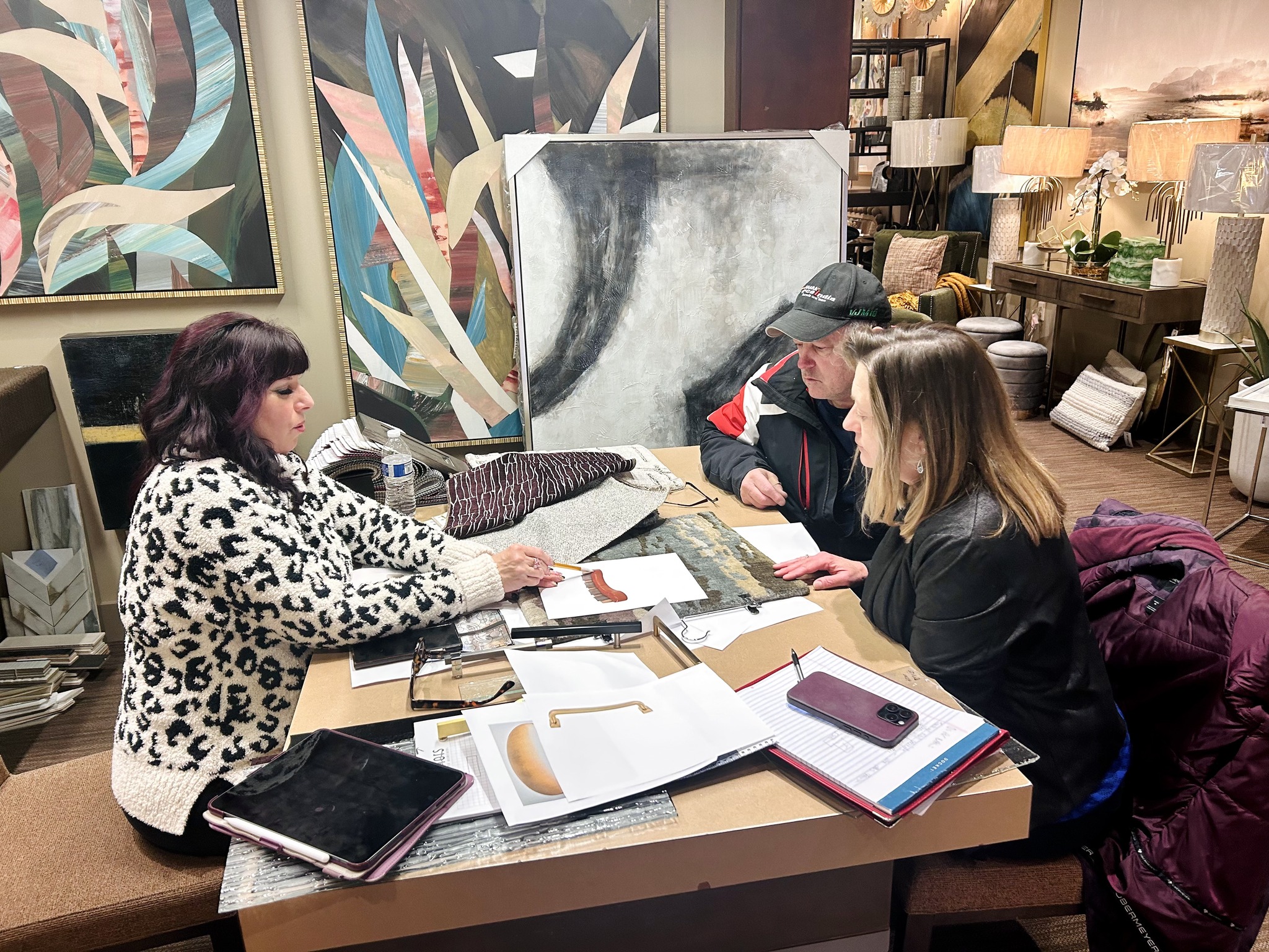 an interior designer at interiors joan and associates works with two clients on their next interior design project